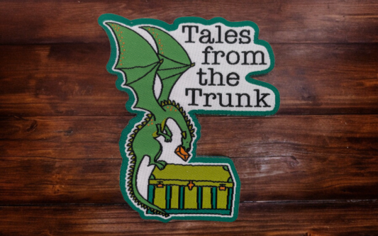 A dragon woven patch with the words Tales from the Trunk written on it.